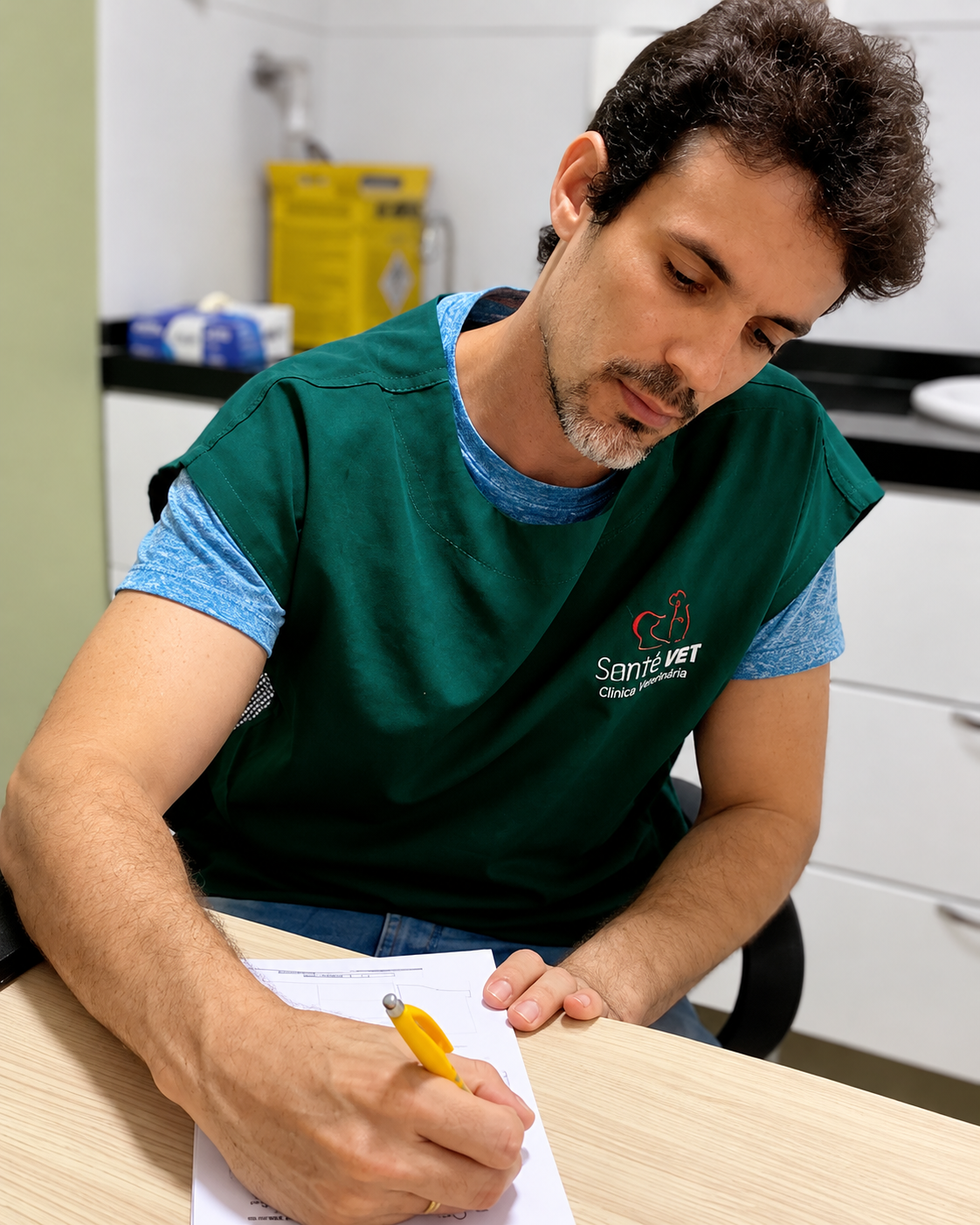 Dr. Henrique, veterinário da Santé Vet, preenchendo uma ficha em consultório com jaleco verde